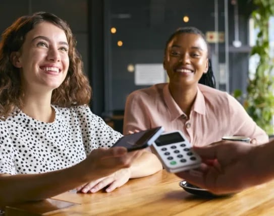 woman-in-coffee-shop-paying-bill-with-contactless